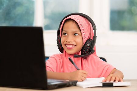Back to school concept,Muslim girls studying online at home To reduce social distance and prevent communicable diseasesの写真素材