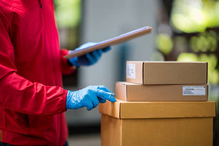 Close up delivery man holding a delivery box packageの写真素材