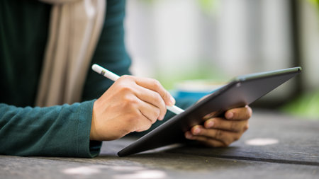 Men use tablets to check business emails at coffee shops.