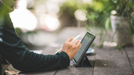 Men use tablets to check business emails at coffee shops.
