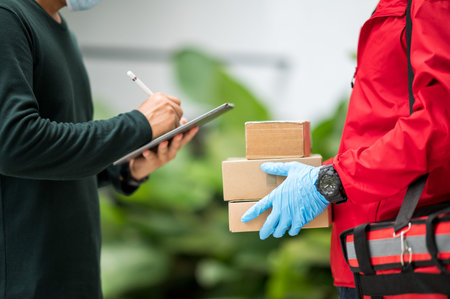 Male customers are signing to sign for delivery from delivery man.