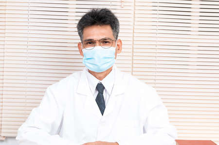 Portrait male doctor wearing a mask with isolated backgroundの写真素材