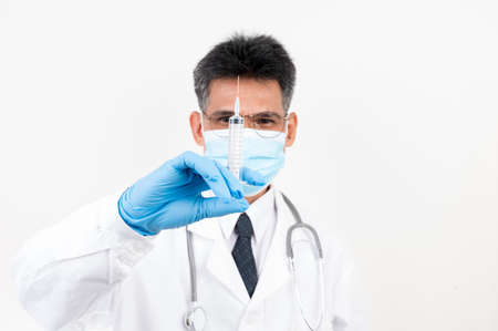 Portrait Male doctor holding a syringe and vaccine bottle with isolated backgroundの写真素材