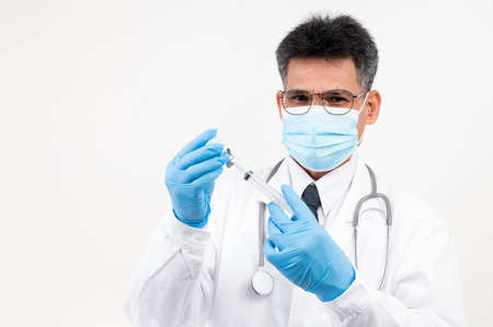 Portrait Male doctor holding a syringe and vaccine bottle with isolated backgroundの写真素材