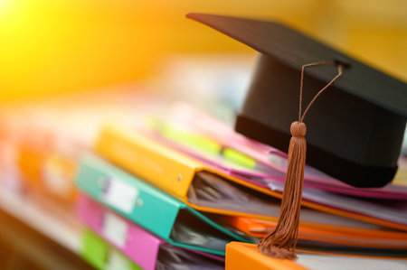 Close up hand of Graduate holding Graduation hat on the green chalkboard background,Education Success Conceptの写真素材