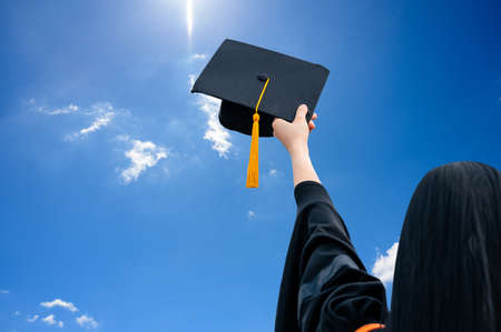 Close up hand of Graduate holding Graduation hat on the green chalkboard background,Education Success Conceptの写真素材
