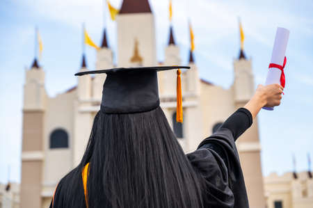 Close up hand of Graduate holding Graduation hat on the green chalkboard background,Education Success Conceptの写真素材