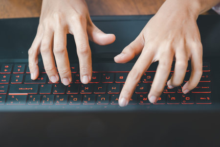 Close up of female hands typing on laptop computer at office