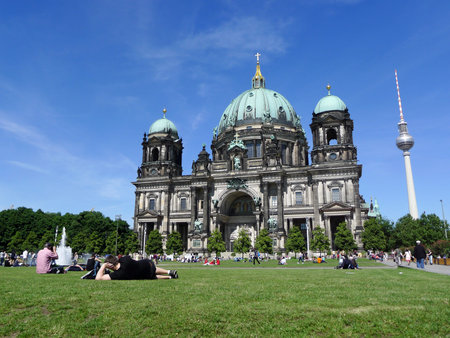 Tourists relaxing at Berlin Cathedral, the mother church during a beautiful sunny day with blue sky...