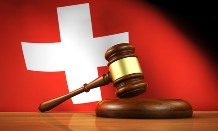 Swiss law and justice concept with a 3d rendering of a gavel on a wooden desktop and the Switzerland flag on background.の写真素材