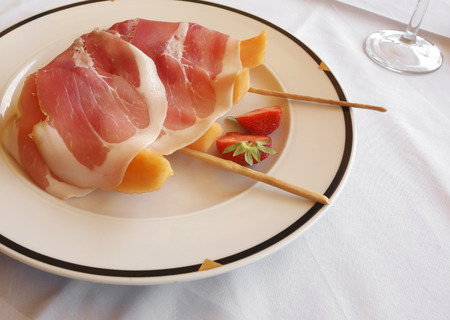 Fresh summer Italian food close-up with ham, melon and strawberry.の写真素材