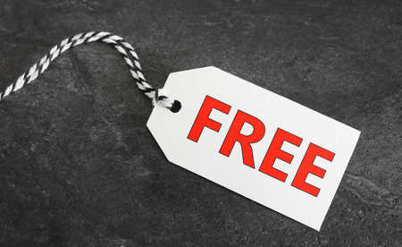 Free word and red sign on a white paper price tag label on dark grey background.の写真素材
