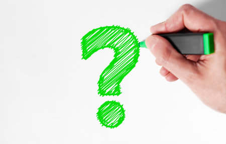 Customer questions and client faqs concept top view close up of a man hand drawing a green question...