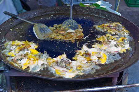 Oysters fried in egg batter being cooked in a panの写真素材