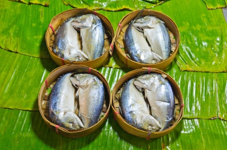 steamed fish Thai style,Steamed fish in a wicker basket placed on a banana leaf の写真素材