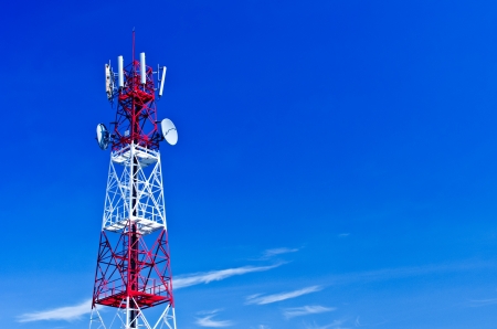 Telecommunications tower, painted white and red in a day of clear blue sky の写真素材