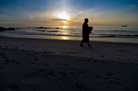 Monk on Hua Hin beach with silhouetteの写真素材