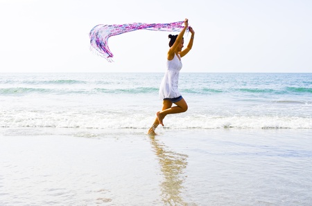 Woman ran a cloth held outdoors on the beach.の写真素材