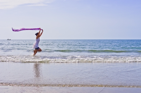 Woman ran a cloth held outdoors on the beach.の写真素材