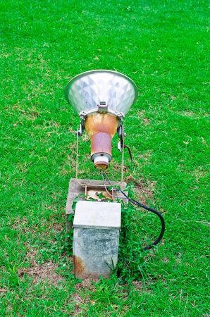 A large spotlight  Installed on a green lawn の写真素材