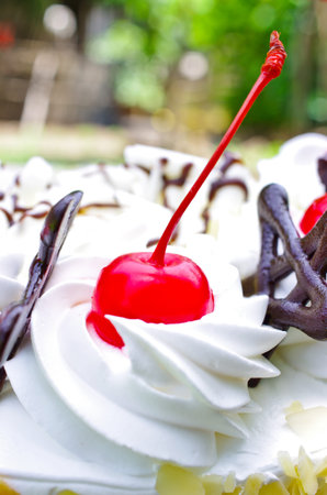 Red cherry on the cake. Natural background.