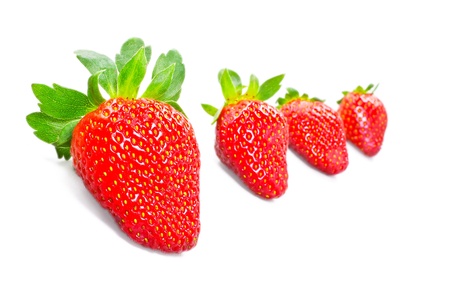 Red strawberry fruits with green leaves isolated on white backgroundの写真素材