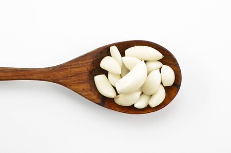 Place the garlic cloves on a wooden spoon.の写真素材