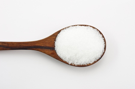 Cane sugar in a wooden spoon. Isolated on white.の写真素材