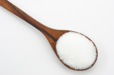 Cane sugar in a wooden spoon. Isolated on white.の写真素材