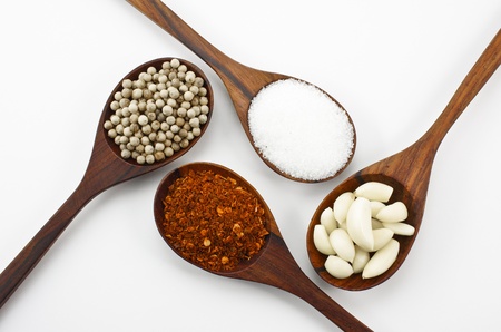 Cayenne pepper, sugar, garlic and pepper,Arranged in a wooden spoon の写真素材