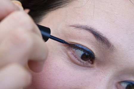 Closeup of Asian Woman Putting Mascara Makeup Eyesの写真素材