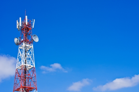 Telecommunications tower, painted white and red in a day of clear blue sky.の写真素材