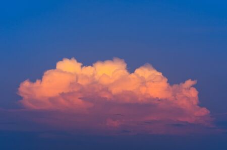 Golden clouds on a blue sky at sunset.の写真素材