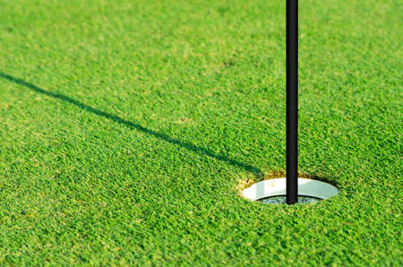 Golf hole with flag embroidered on the lawn.の写真素材