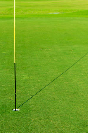 Golf hole with flag embroidered on the lawn.の写真素材