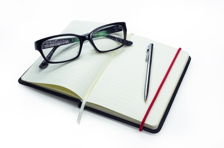 Pencil and black frame glasses on the notebook, Isolated on white. Business concept.の写真素材