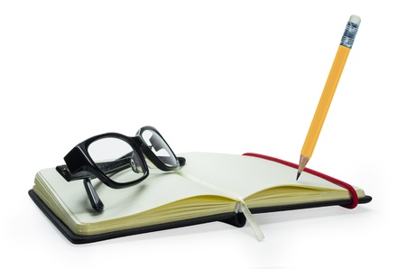 Pencil and black frame glasses on the notebook, Isolated on white. Business concept.の写真素材