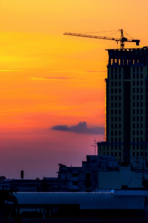 Building under construction and a crane. During Sunrise.の写真素材
