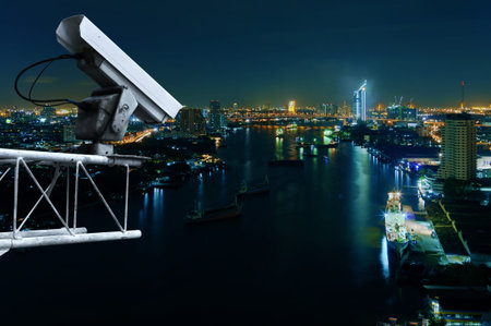 Security cameras monitor the movement of the top of the building, Aerial view of Bangkok along Chaophraya River.の写真素材