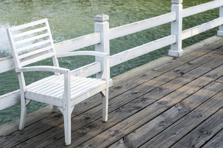 White wooden chair beside the walkway.の写真素材