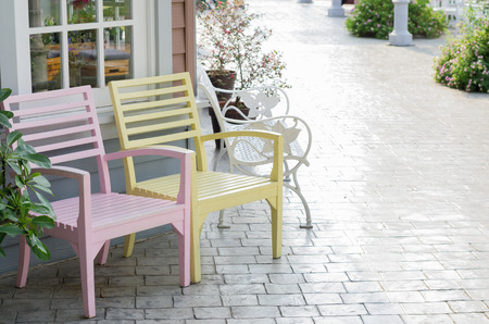 Pink and yellow wooden chair beside the walkway.の写真素材