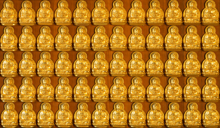 Golden Buddha Small, on a wall in the temple.の写真素材
