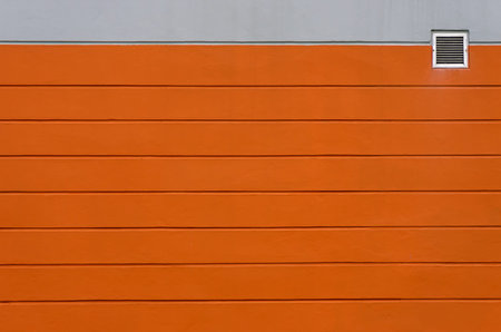 Orange and gray concrete wall. With small vents For background