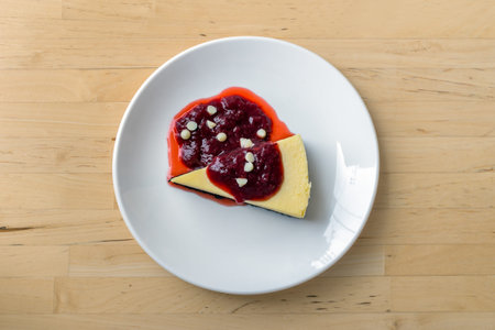 White chocolate cheesecake topped with strawberry cream berries on a white plate, Top view.