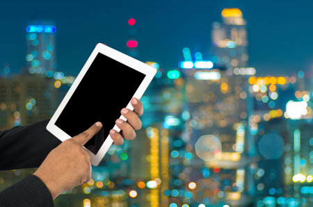 Businessman using tablet pc and city landscape at background.