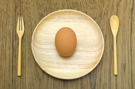 Breakfast concept, eggs on wood background old wooden spoon and fork.の写真素材