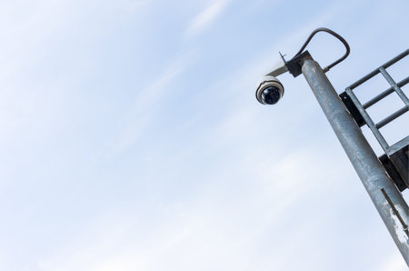 Security cameras on a pole above the intersection. Check the traffic on the road.