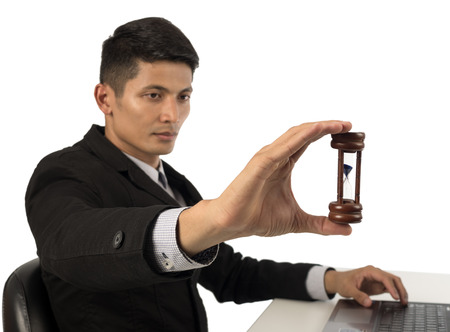 close up of business man hand holding hourglass.の写真素材