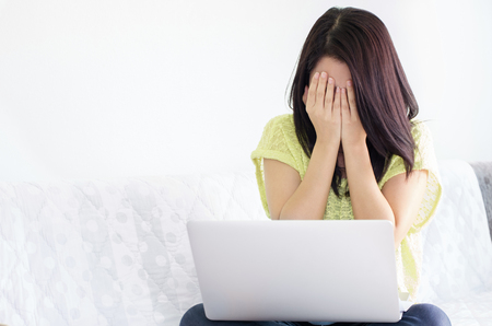 Stress young beautiful asian woman using a laptop on the bed at home.の写真素材