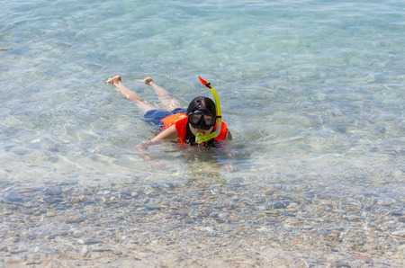 Asian woman wearing a life vest and diving mask. See shallow water coral beach, Koh Kham, Chonburi, Thailand.の写真素材